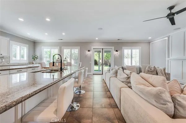 a large living room with stainless steel appliances granite countertop couches a fireplace a flat screen tv and a large window