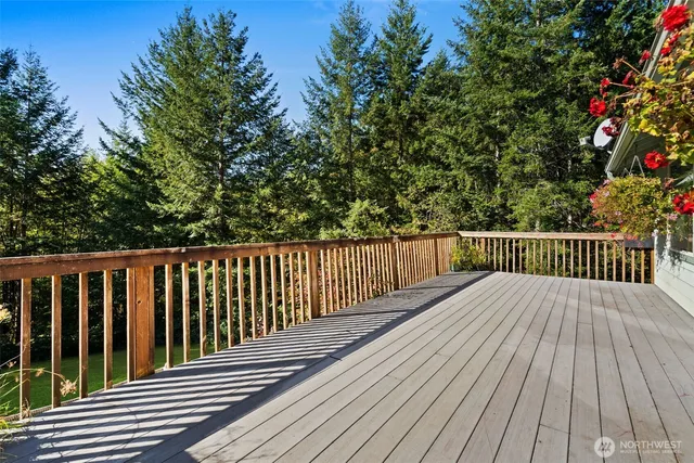 a balcony with wooden floor and trees in the background