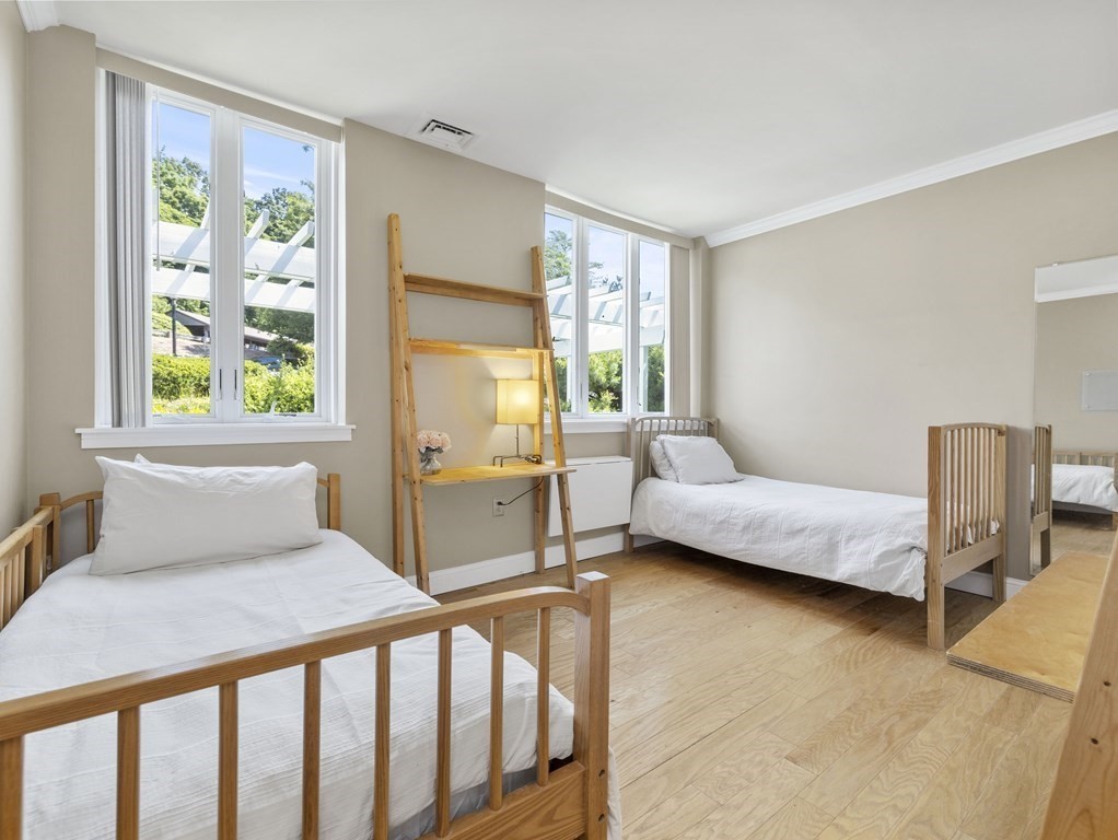 64 Ober Road, Unit 64 Newton, MA 02459 - Photo 3 of 26 a bedroom with a bed and wooden floor