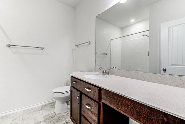 1237 Volente Lane Leander, TX 78641 - Photo 10 of 22 A well-appointed bathroom features a single vanity, a standard toilet, and a practical shower with clean white tile.