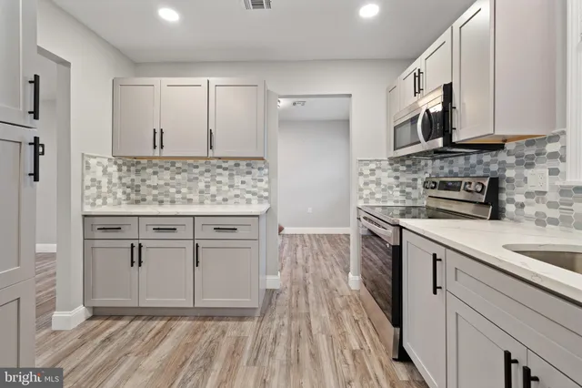 a kitchen with stainless steel appliances granite countertop a stove a sink and a microwave