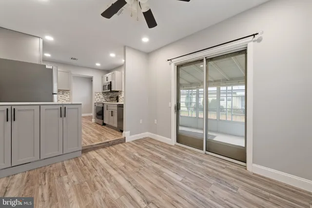 a view of empty room with wooden floor and window