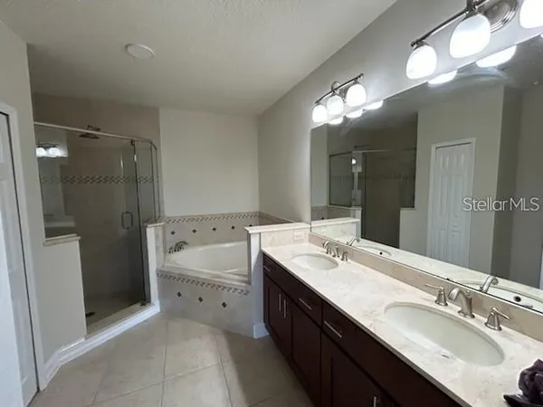 a bathroom with a double vanity sink a toilet and shower