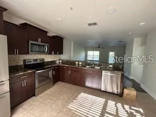 a kitchen with stainless steel appliances granite countertop a stove sink and cabinets