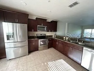a kitchen with granite countertop a refrigerator and a sink