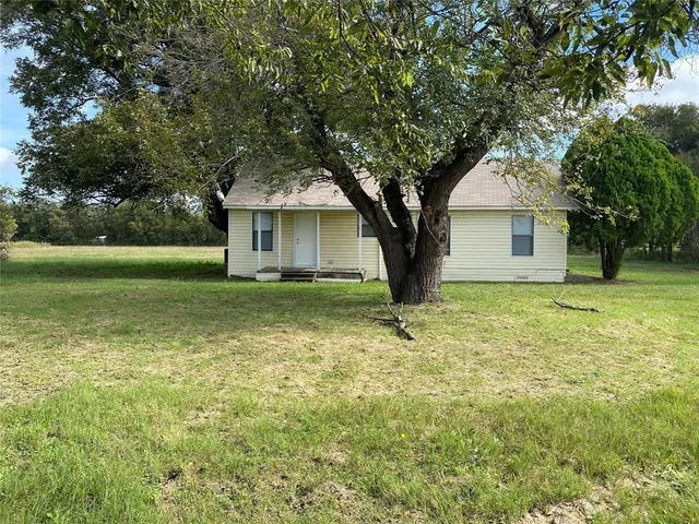 a white house that has a tree in front of it