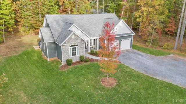 a view of a house with a yard and large tree