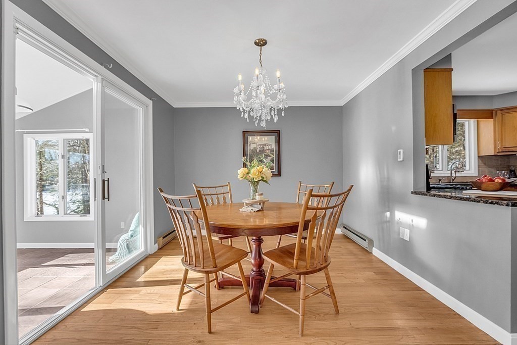 105 Secret Lake Road Phillipston, MA 01331 - Photo 14 of 42 a view of a dining room with furniture a chandelier and wooden floor