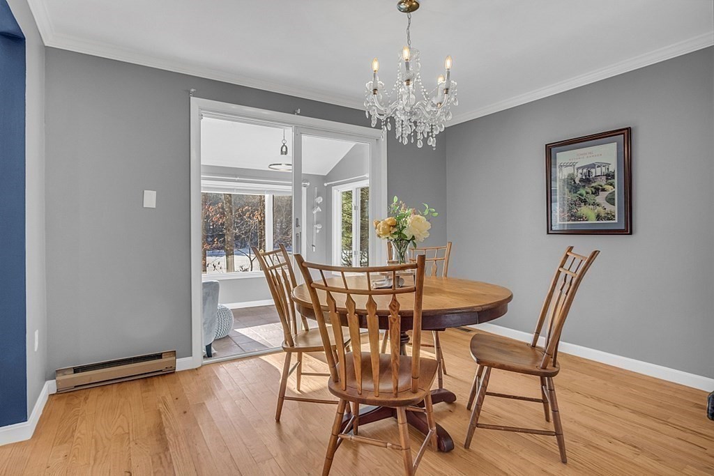 105 Secret Lake Road Phillipston, MA 01331 - Photo 15 of 42 a view of a dining room with furniture a chandelier and wooden floor