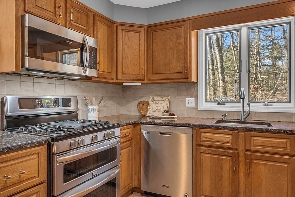 105 Secret Lake Road Phillipston, MA 01331 - Photo 26 of 42 a kitchen with stainless steel appliances granite countertop a sink stove and microwave