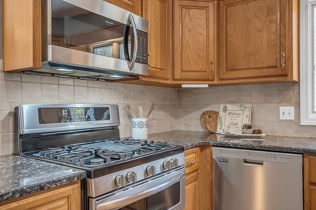 105 Secret Lake Road Phillipston, MA 01331 - Photo 27 of 42 a kitchen with granite countertop stainless steel appliances stove top oven and cabinets