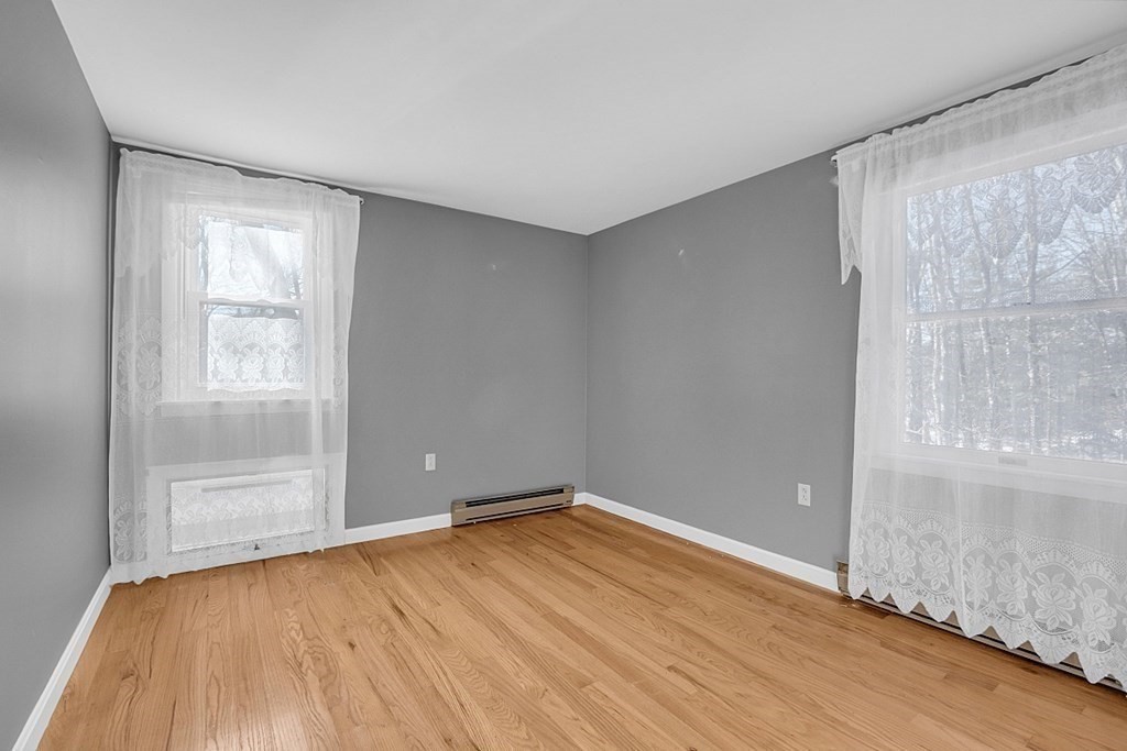 105 Secret Lake Road Phillipston, MA 01331 - Photo 31 of 42 an empty room with wooden floor and windows