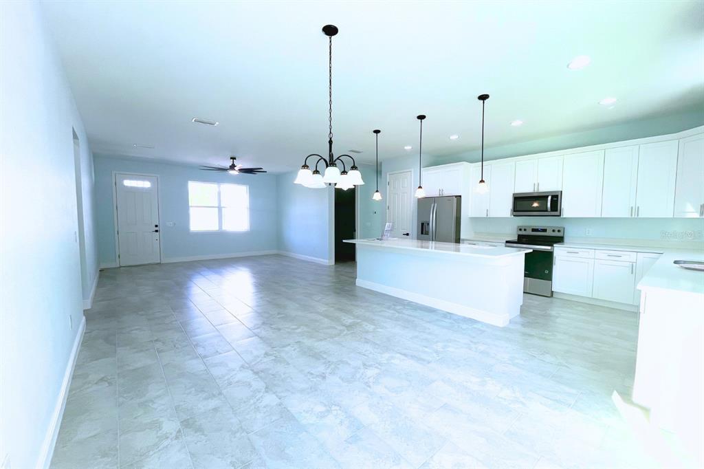 12222 Southwest 95th Place Dunnellon, FL 34432 - Photo 6 of 17 a view of a kitchen with kitchen island white cabinets and stainless steel appliances