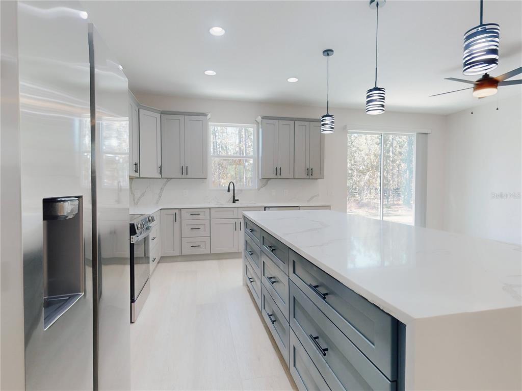 12222 Southwest 95th Place Dunnellon, FL 34432 - Photo 7 of 23 a kitchen with stainless steel appliances granite countertop a sink stove and refrigerator