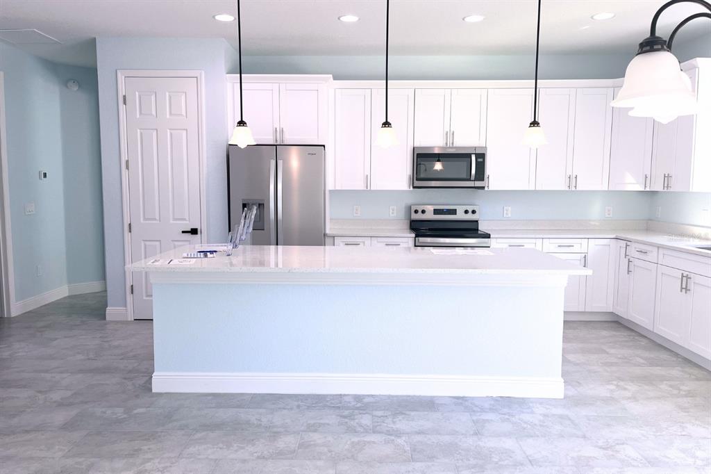 12222 Southwest 95th Place Dunnellon, FL 34432 - Photo 7 of 17 a kitchen with stainless steel appliances a refrigerator sink and stove