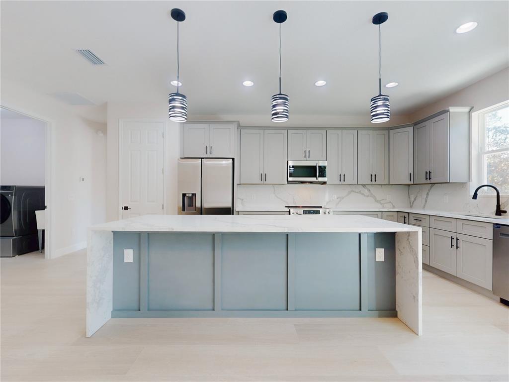 12222 Southwest 95th Place Dunnellon, FL 34432 - Photo 9 of 23 a kitchen with stainless steel appliances granite countertop a sink a center island a cabinets and a window