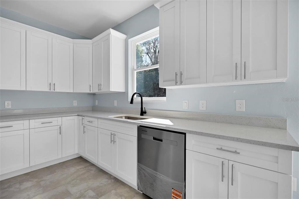 12222 Southwest 95th Place Dunnellon, FL 34432 - Photo 9 of 17 a kitchen with white cabinets and sink