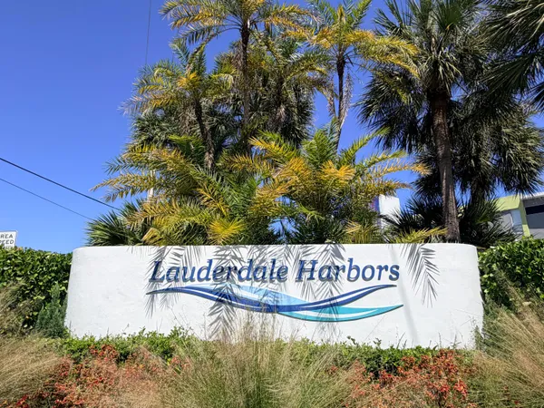 a view of sign board with flower plants