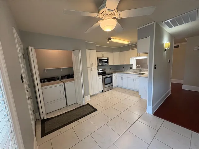 a view of a kitchen with a refrigerator and a stove top oven
