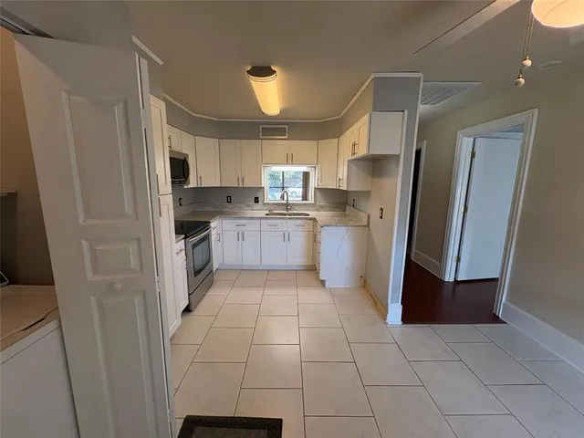 a kitchen with stainless steel appliances granite countertop a refrigerator and a sink