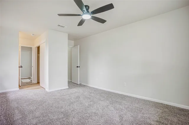 an empty room with closet and fan