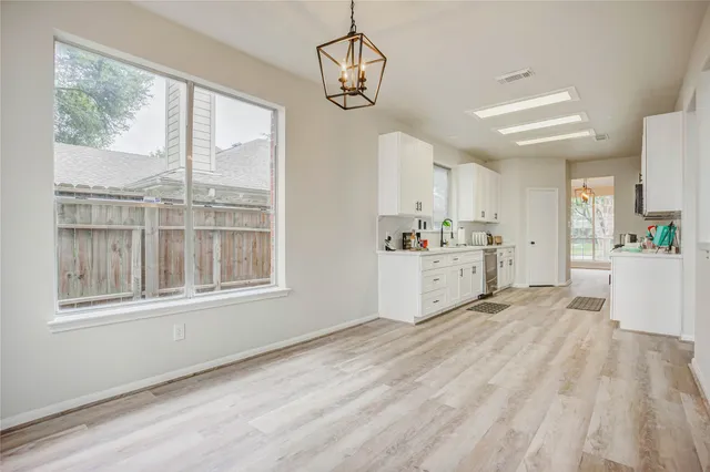 a view of a kitchen with wooden floor and windows