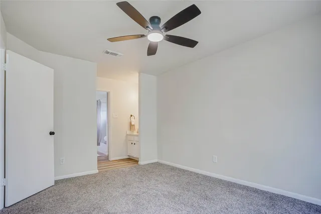 an empty room with closet and a chandelier fan