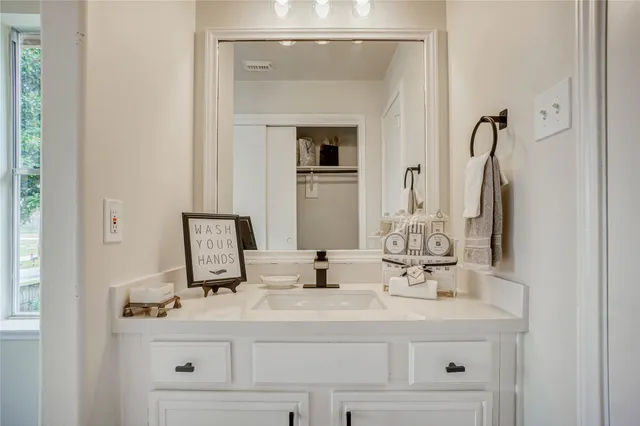 a bathroom with a sink vanity and a mirror