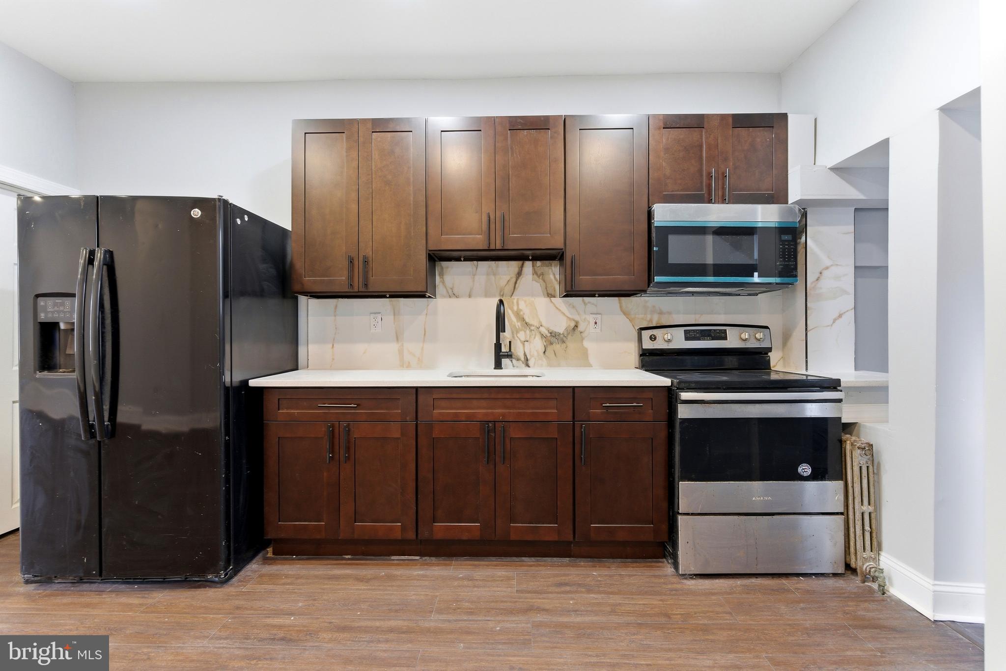 7233 West Chester Pike Upper Darby, PA 19082 - Photo 5 of 14 a kitchen with stainless steel appliances granite countertop a refrigerator and a sink