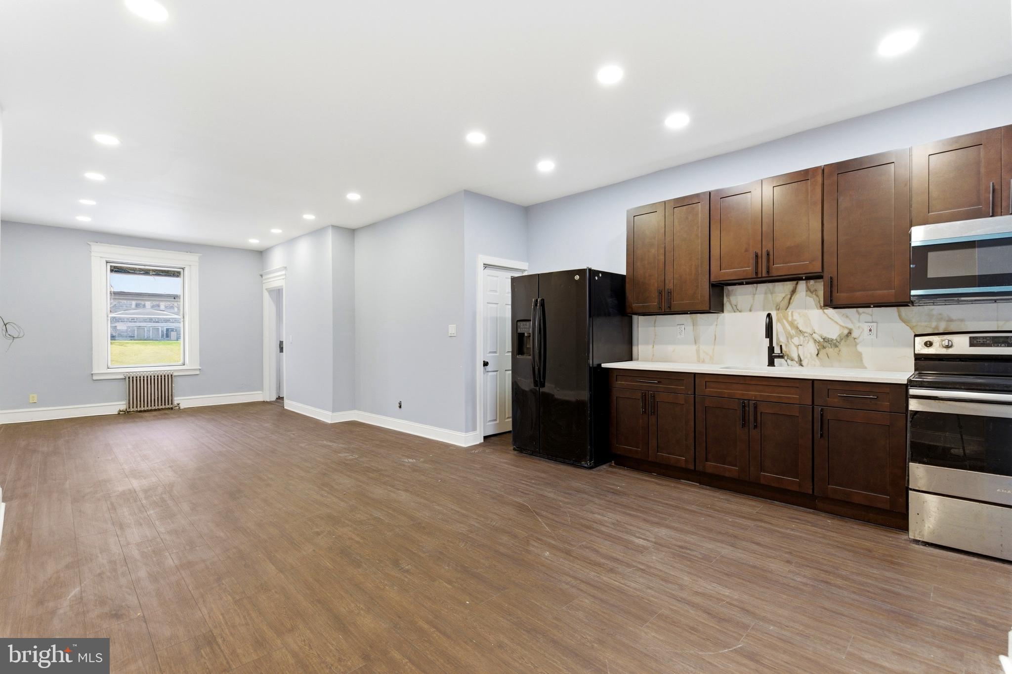 7233 West Chester Pike Upper Darby, PA 19082 - Photo 6 of 14 a kitchen with stainless steel appliances kitchen island granite countertop a refrigerator a sink a stove a microwave and cabinets