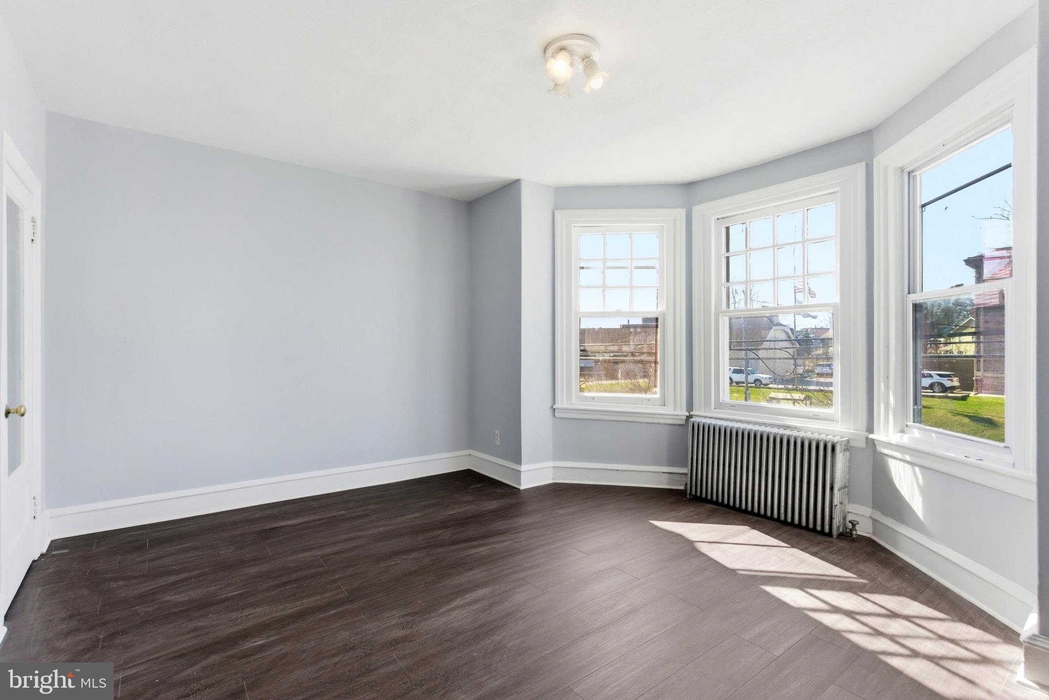 7233 West Chester Pike Upper Darby, PA 19082 - Photo 8 of 14 an empty room with wooden floor and windows