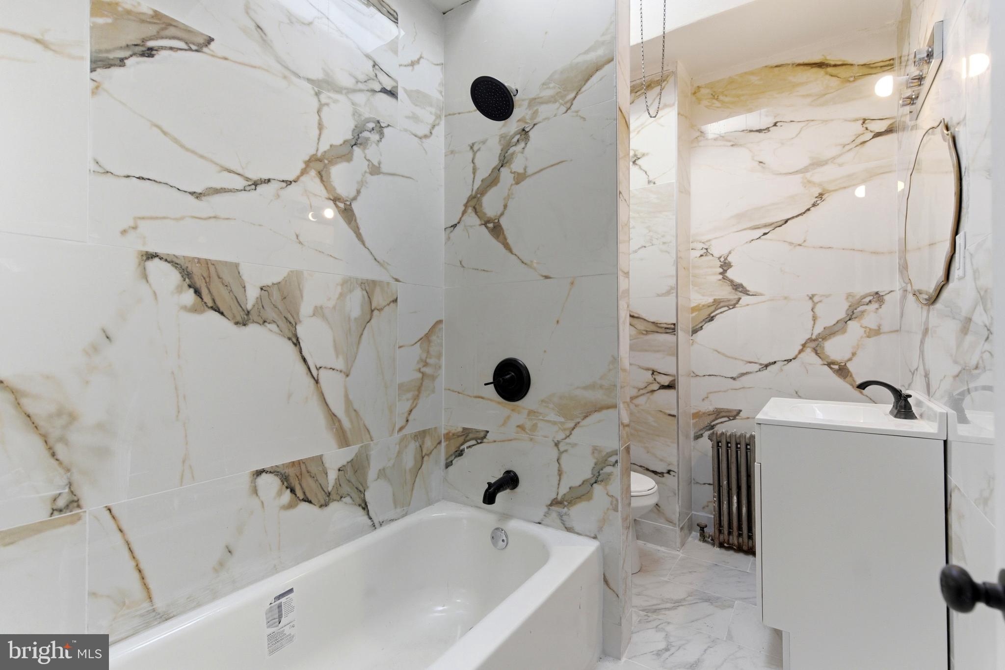 7233 West Chester Pike Upper Darby, PA 19082 - Photo 10 of 14 a bathroom with a sink and mirror with bathtub