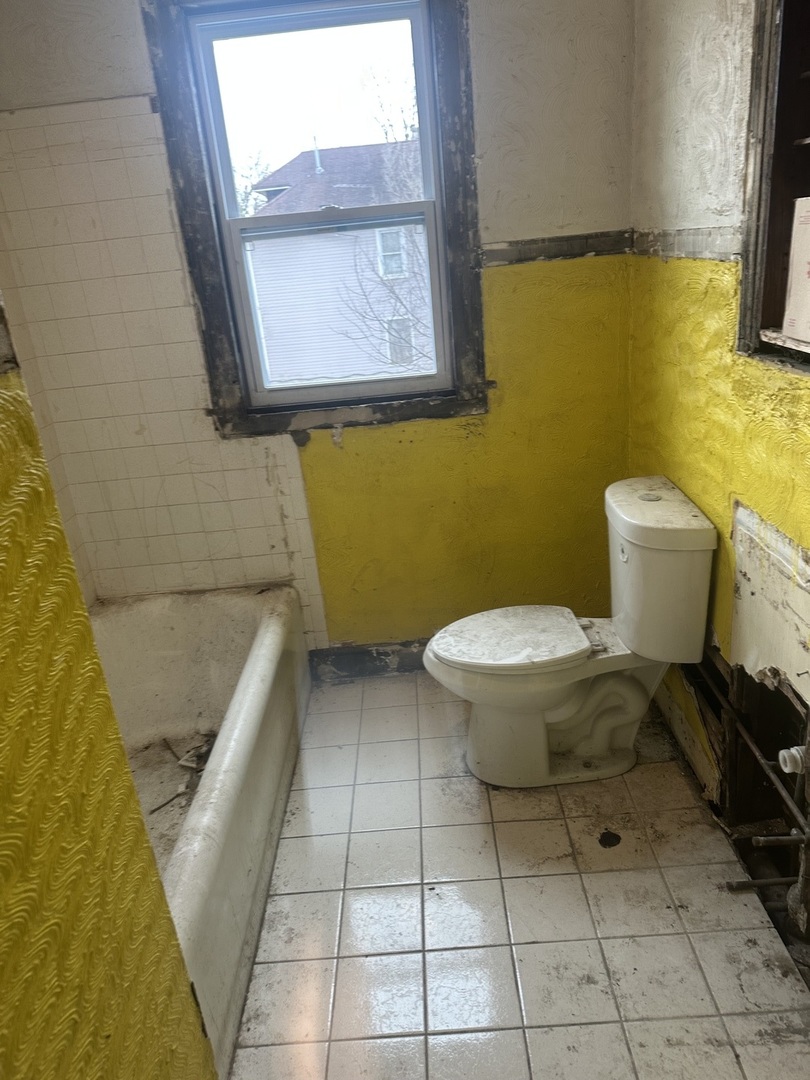 11809 South Indiana Avenue Chicago, IL 60628 - Photo 12 of 21 a bathroom with a toilet and a mirror