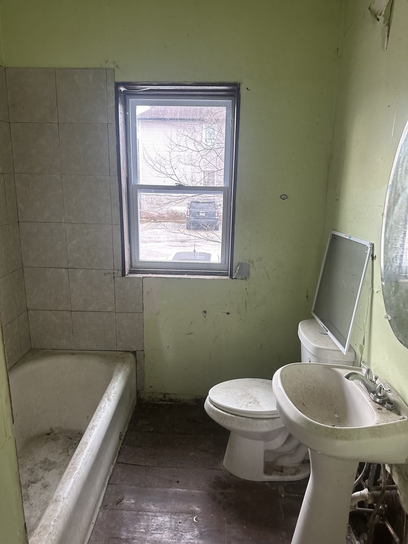 11809 South Indiana Avenue Chicago, IL 60628 - Photo 8 of 21 a bathroom with a toilet and a bathtub