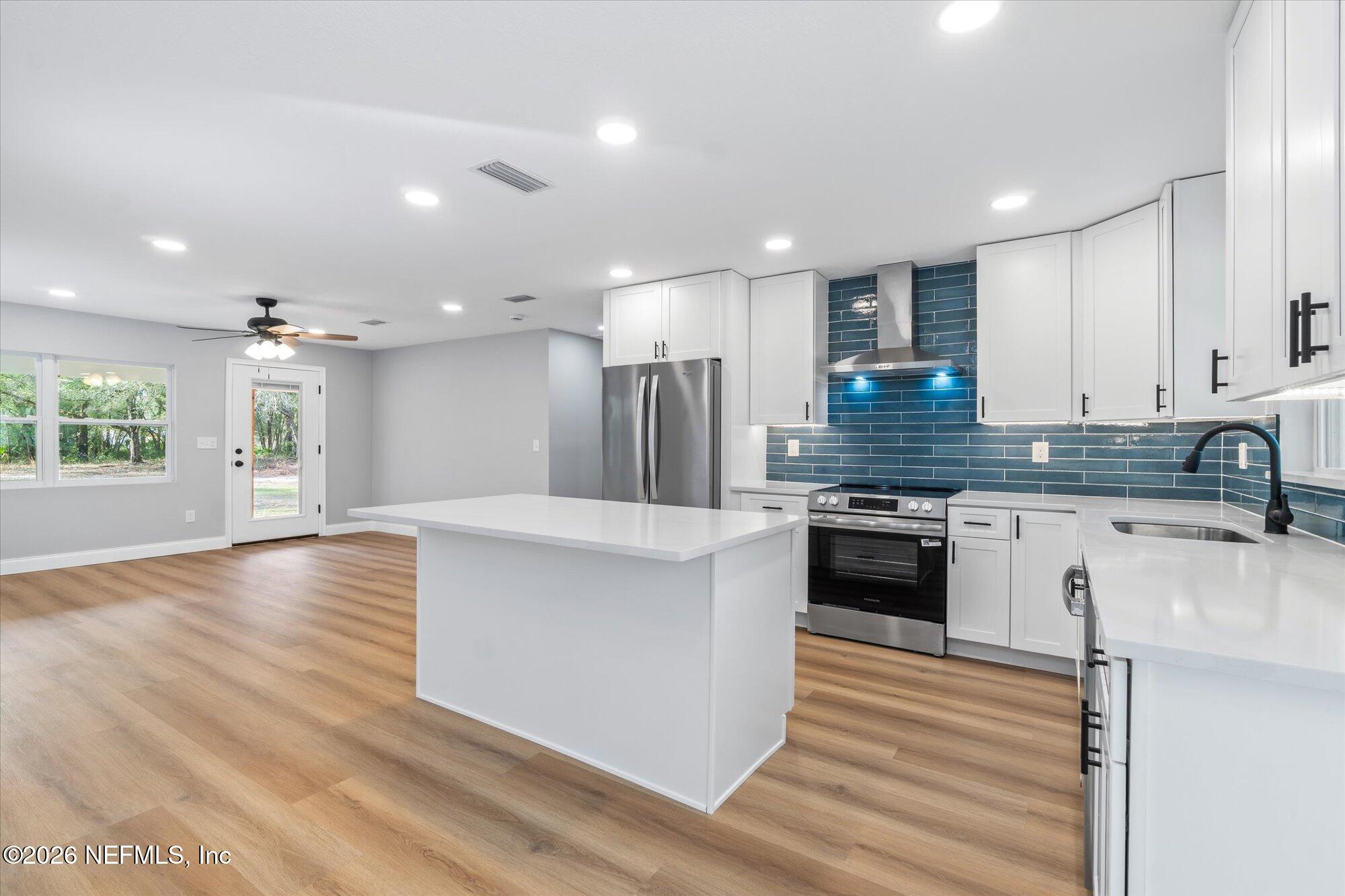 102 Mullins Road Interlachen, FL 32148 - Photo 11 of 45 a large kitchen with stainless steel appliances granite countertop a stove a sink and a refrigerator