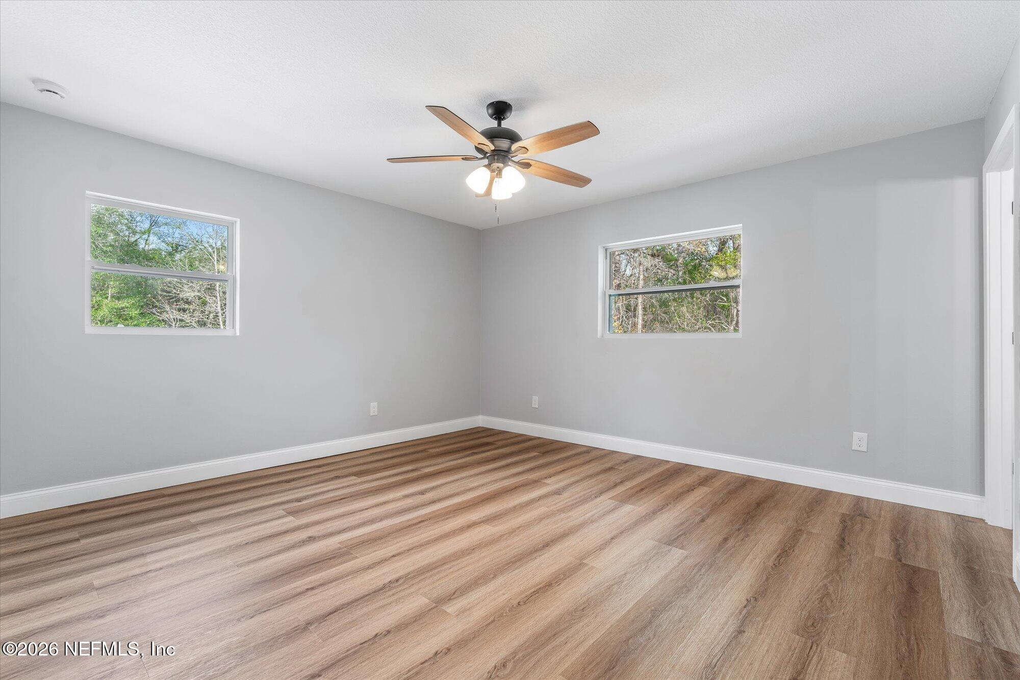 102 Mullins Road Interlachen, FL 32148 - Photo 17 of 45 a view of an empty room with window and wooden floor