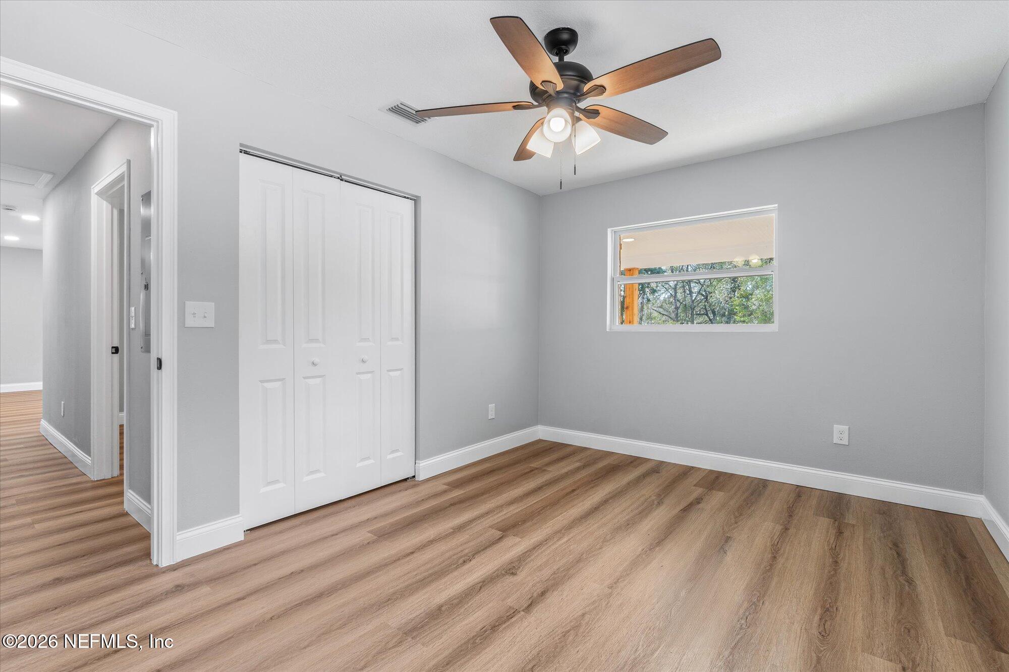 102 Mullins Road Interlachen, FL 32148 - Photo 27 of 45 an empty room with wooden floor and windows