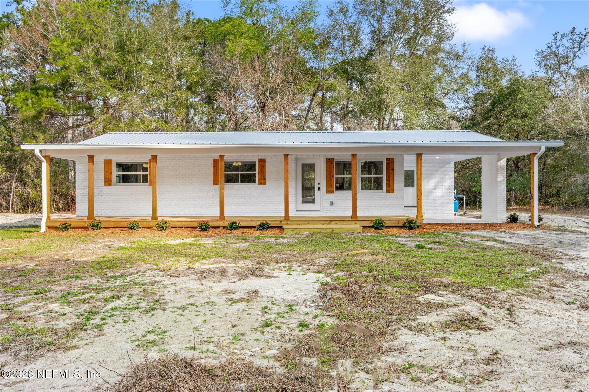 102 Mullins Road Interlachen, FL 32148 - Photo 34 of 45 a house that has a big yard large trees with wooden fence