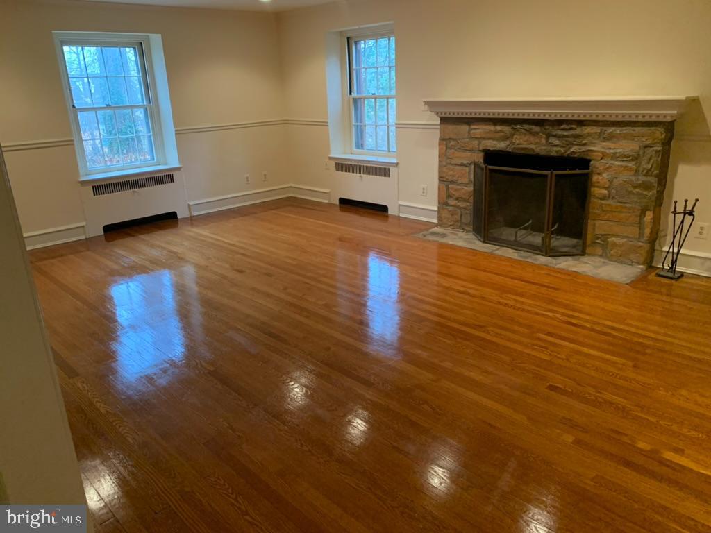 602 Bellevue Road Wilmington, DE 19809 - Photo 14 of 56 an empty room with wooden floor fireplace and windows