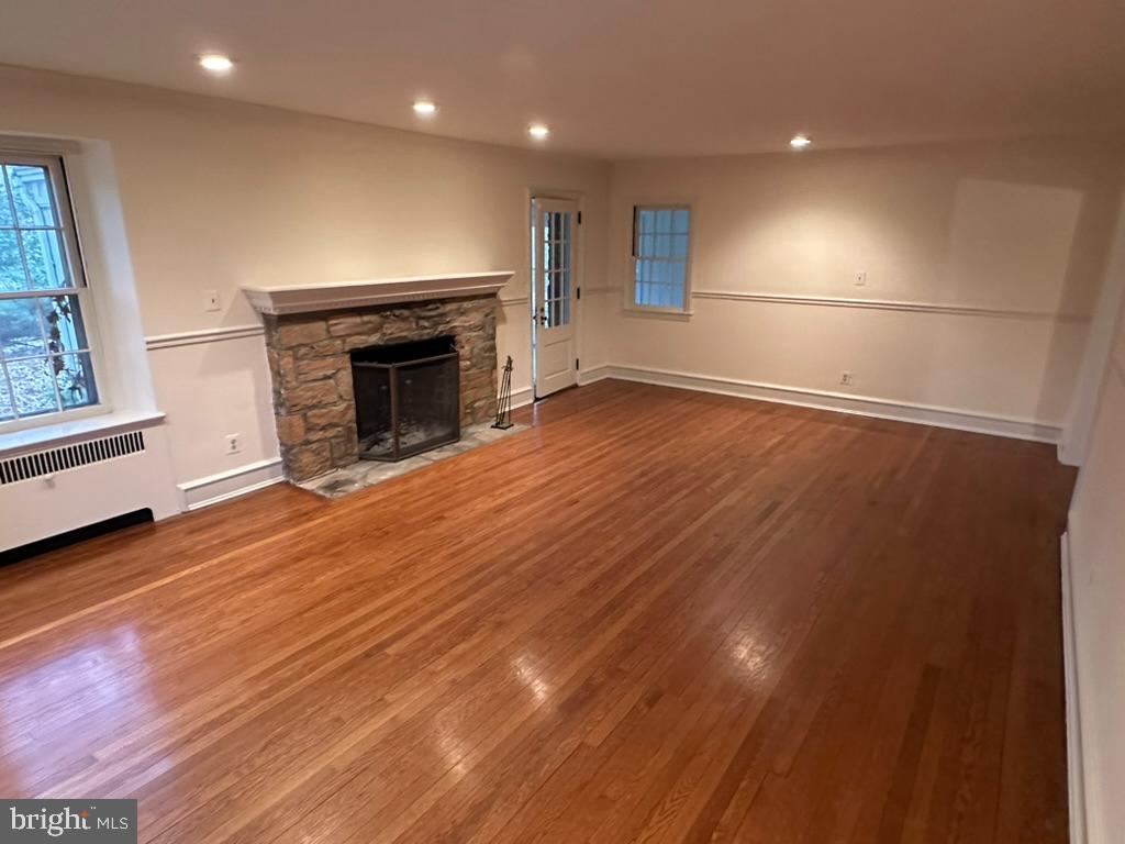 602 Bellevue Road Wilmington, DE 19809 - Photo 15 of 56 an empty room with wooden floor fireplace and windows