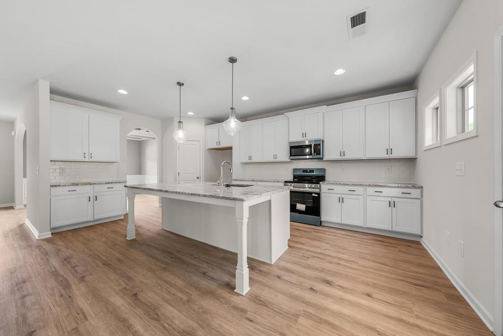 623 Bohannon Road Grantville, GA 30220 - Photo 11 of 34 a large kitchen with cabinets wooden floor and stainless steel appliances