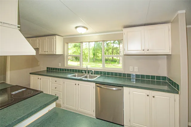 a kitchen with granite countertop a sink and a stove