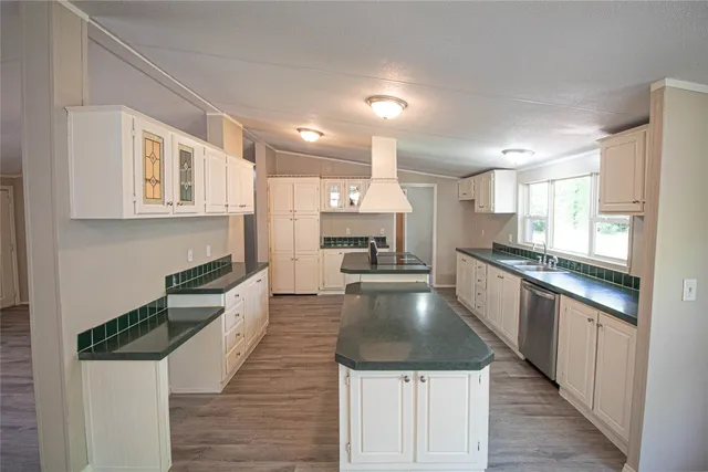 a large kitchen with stainless steel appliances lots of counter space and wooden floor