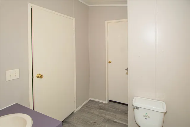 a bathroom with a granite countertop toilet and a sink