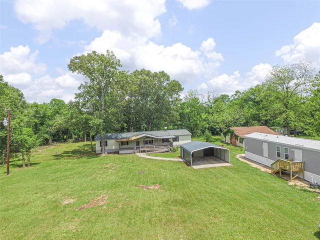a view of a house with a yard and sitting area
