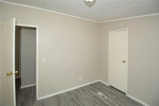 an empty room with wooden floor and closet