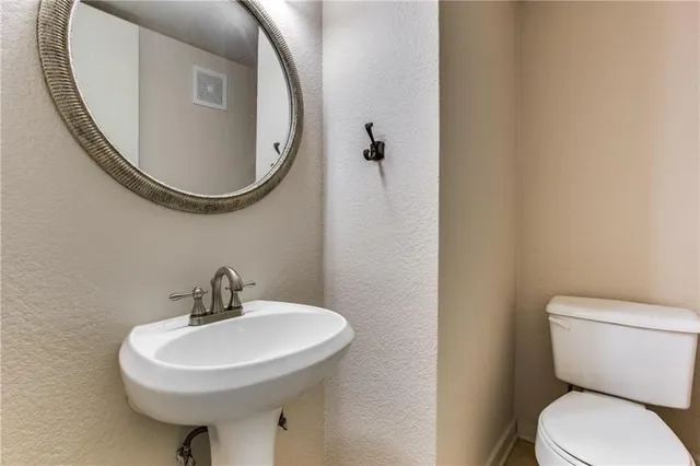 a bathroom with a sink a mirror and a toilet