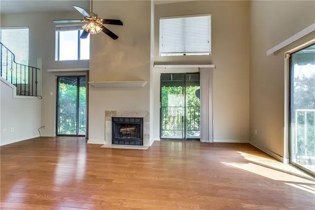 wooden floor fireplace and windows in an empty room