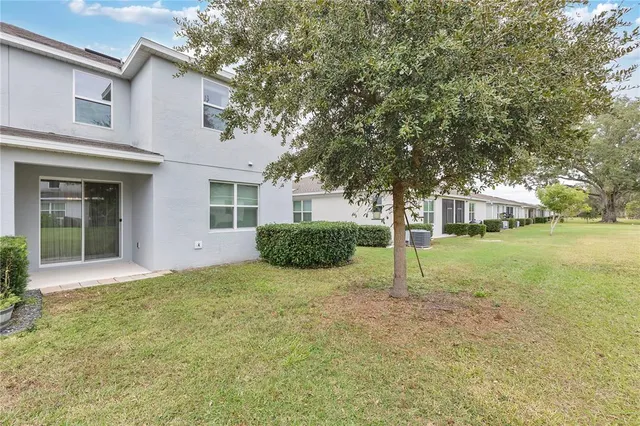 a view of a house with backyard and tree
