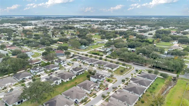 an aerial view of residential houses with outdoor space and trees